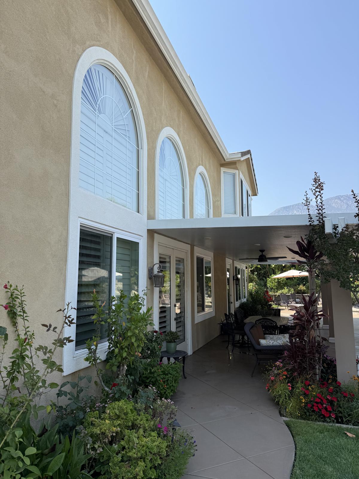 Tall arched specialty windows cleaned on a custom two-story home