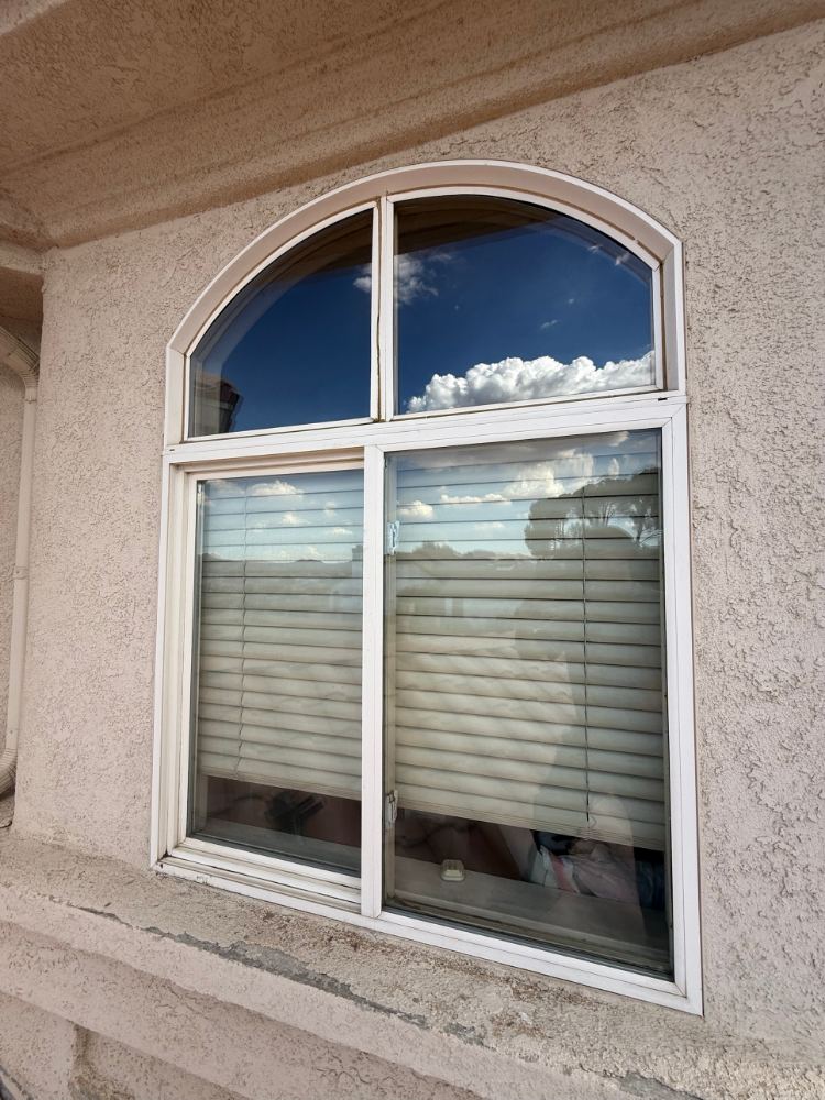 Arched transom and sliding window at a Spring Valley Lake home after cleaning and hard water restoration, glass reflecting the sky