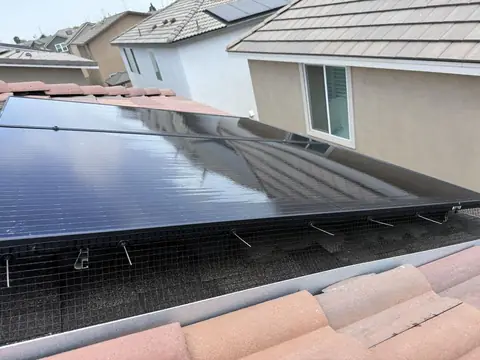 Close view of mesh clipped under the edge of a Hesperia solar array