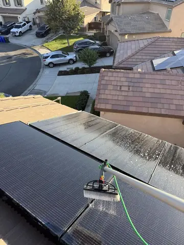 Soft brush on a water fed pole washing solar panels in Hesperia, clean next to dusty