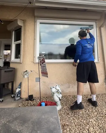 Tony squeegeeing a large picture window at a Hesperia home