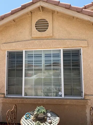 Clean back patio window with shutters on a Phelan home